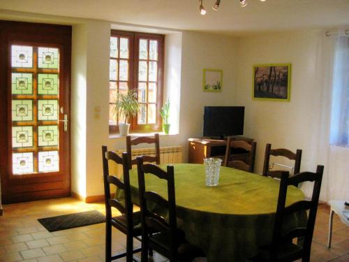 une salle à manger avec une table, des chaises et une télévision dans l'établissement Gîte familial en Touraine avec jardin, proche châteaux et vignobles, animaux acceptés. - FR-1-381-240, à Mazières-de-Touraine