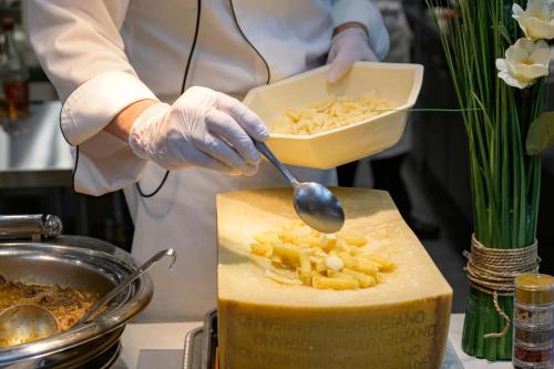 a person holding a bowl of food with a spoon at Senkeien Tsukioka Hotel in Kaminoyama