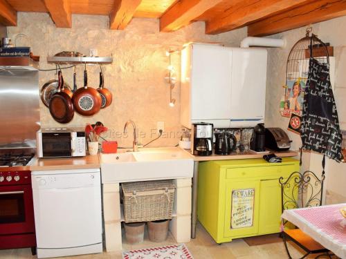 une petite cuisine avec un évier et une cuisinière dans l'établissement Gîte de Charme Rénové, Idéal Famille, Centre-Ville, WiFi, Parking Gratuit, Vélo Bienvenue - FR-1-381-268, à Loches