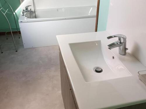 La salle de bains est pourvue d'un lavabo blanc et d'une baignoire. dans l'établissement Gîte Saint-Omer, 4 pièces, 7 personnes - FR-1-376-72, à Saint-Omer