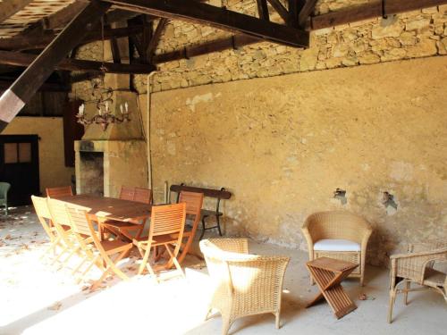 Cette chambre dispose d'une table et de chaises en bois. dans l'établissement Maison de charme à La Roque-Gageac avec jardin, terrasse et équipements bébé - FR-1-616-136, à La Roque-Gageac