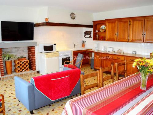 une cuisine et une salle à manger avec une table et une chaise rouge dans l'établissement Gîte charmant près de Tours et Amboise avec Wi-Fi, cour privative, garage à vélos, accepte animaux - FR-1-381-503, à Vernou-sur-Brenne