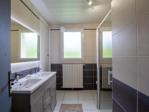 La salle de bains est pourvue d'un lavabo, d'un radiateur et de 2 fenêtres. dans l'établissement Maison périgourdine rénovée, 3 chambres, grand jardin, proche Sarlat et sites touristiques - FR-1-616-211, à Saint-Vincent-le-Paluel