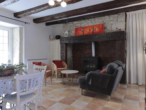 a living room with a couch and a fireplace at Maison Périgourdine Authentique avec Cheminée, Jardin, Cuisine d'Été et Visite de Truffière - FR-1-616-239 in Tourtoirac