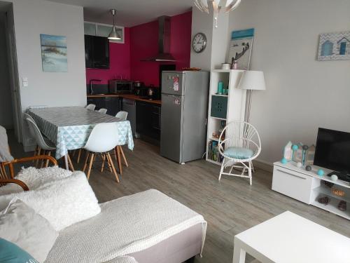 un salon avec une table et une cuisine dans l'établissement Appartement rénové face à la mer avec balcon - 2 chambres - Saint-Jean-de-Monts - FR-1-323-472, à Saint-Jean-de-Monts