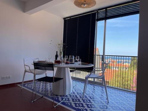 une salle à manger avec une table et des chaises et un balcon dans l'établissement Charmant T2 climatisé dans résidence sécurisée, proche plage - FR-1-309-394, à Collioure