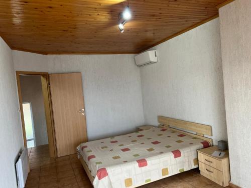 ein Schlafzimmer mit einem Bett und einer Holzdecke in der Unterkunft karakolev 3 in Obrochishte