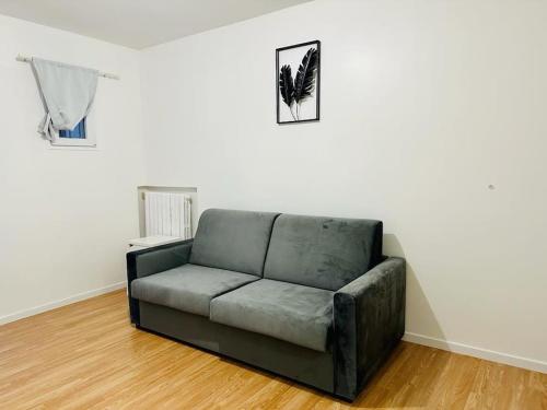 - un canapé installé dans un salon à côté d'un mur dans l'établissement Superbe studio proche du Casino/Stade de France, à Soisy-sous-Montmorency