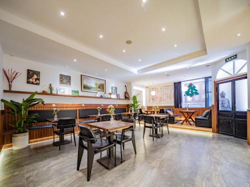 a restaurant with tables and chairs in a room at Joke Inn in Xi'an