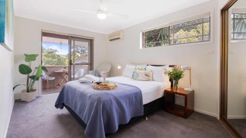 a bedroom with a bed and a table with a basket on it at Bombo Blue in Kiama