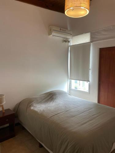 une chambre avec un lit blanc et une fenêtre dans l'établissement Departamento Emilia 1, à Chascomús