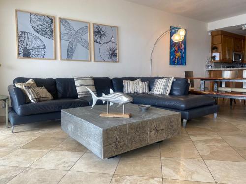 a living room with a blue couch and a table at Playa Blanca Condo - 9th Floor Ocean Views! in San Carlos