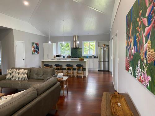 a living room with a couch and a kitchen at Are'ora - the house for living in Rarotonga