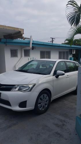 a white car parked in front of a house at Holiday Hire Fiji in Lautoka