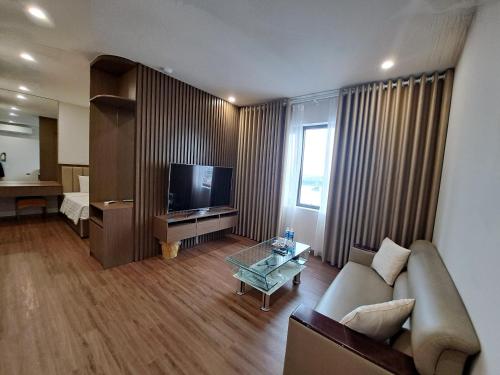 a living room with a couch and a television at Glory Hotel Apartment Hải Phòng in Hai Phong
