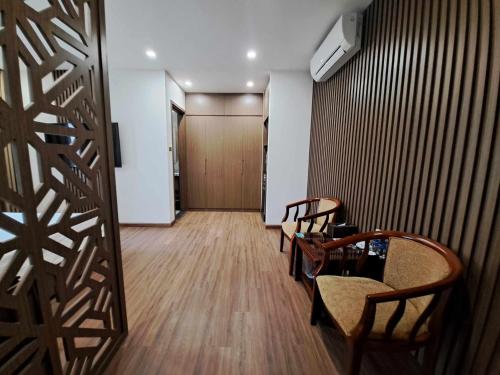 a hallway with two chairs and a door to a room at Glory Hotel Apartment Hải Phòng in Hai Phong