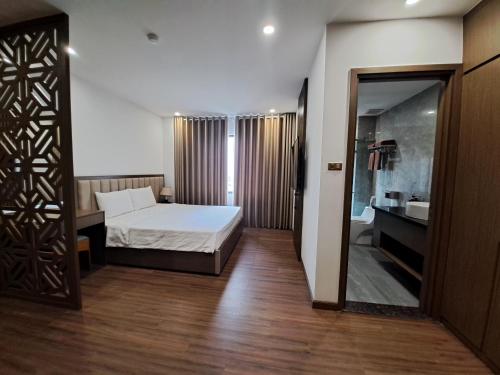 a bedroom with a bed and a bathroom at Glory Hotel Apartment Hải Phòng in Hai Phong