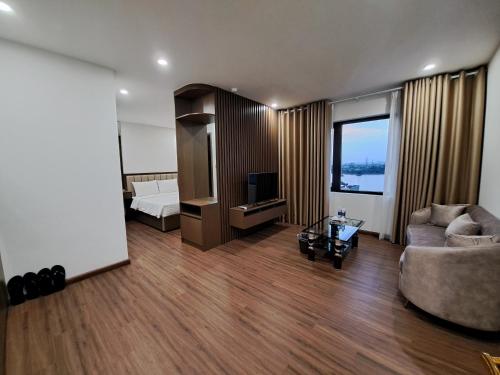 a living room with a couch and a television at Glory Hotel Apartment Hải Phòng in Hai Phong