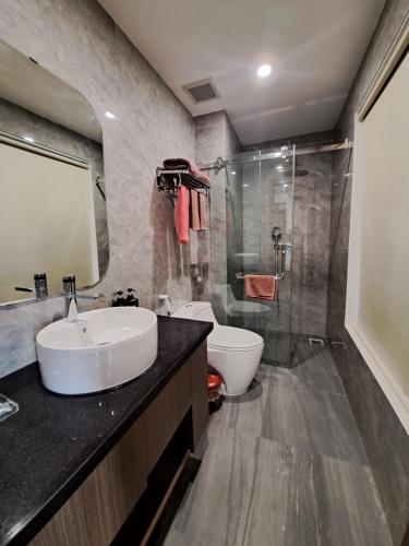 a bathroom with a sink and a toilet and a shower at Glory Hotel Apartment Hải Phòng in Hai Phong