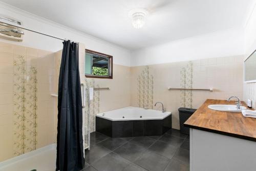 a bathroom with a tub and a sink at Unwind on Prince in Urangan
