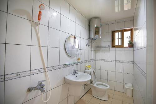 a white bathroom with a sink and a toilet at 芹壁山莊 in Beigan