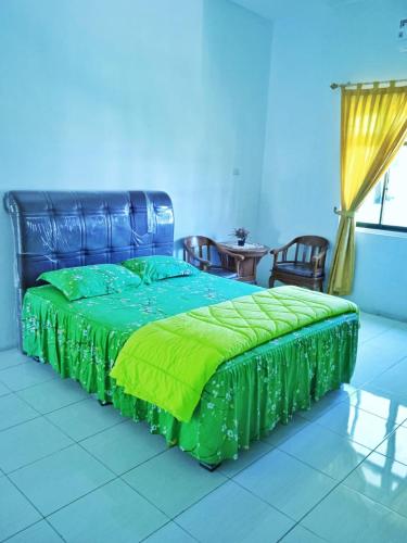 1 dormitorio con 1 cama con edredón verde en HOTEL ANANDA, 