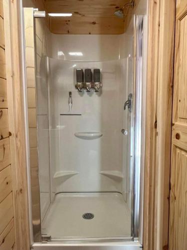 a shower with a glass door in a bathroom at Chalet La P'tite Paix in Saint-Alexis-des-Monts