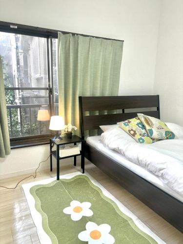 1 dormitorio con cama y alfombra verde en 東京 足立区青井 Tokyo Adachiku Aoi en Tokio