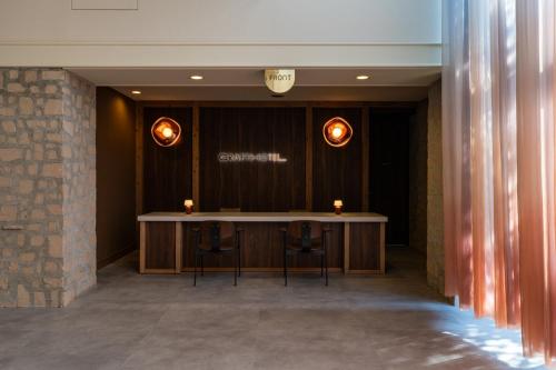 una sala de conferencias con una mesa y dos taburetes en クラフトホテル瀬戸内, en Higashikagawa