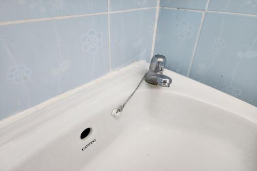 a bath tub with a faucet on top of it at Kim Hotel At Bangplong in Ban Bang Prong