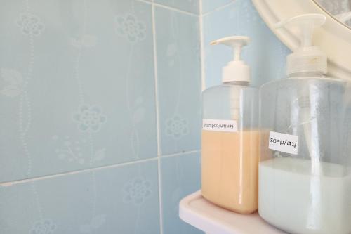 a bathroom with two bottles of soap on a sink at Kim Hotel At Bangplong in Ban Bang Prong