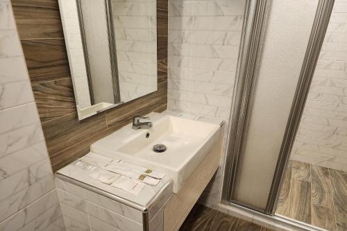 a bathroom with a white sink and a mirror at Kim Hotel At Bangplong in Ban Bang Prong