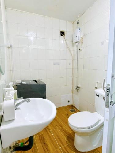 uma casa de banho com um WC branco e um lavatório. em SÀI GÒN INN ĐỀ THÁM em Ho Chi Minh