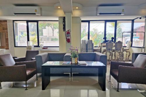 Kim Hotel At Bangplong في Ban Bang Prong: غرفة انتظار مع كراسي وطاولة في الغرفة