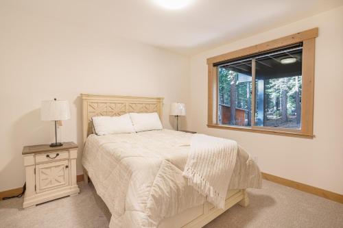 a white bedroom with a bed and a window at Wooded Bliss in Carnelian Bay