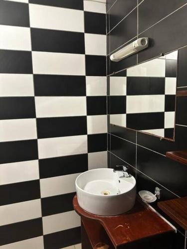 a bathroom with a black and white checkered wall at Montjoly Rémire Confort Studio 03 in Rémiré