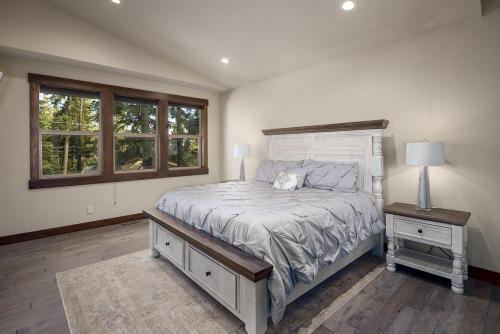 a bedroom with a bed and a table with a lamp at Tahoe Tranquili-Tree in Kings Beach