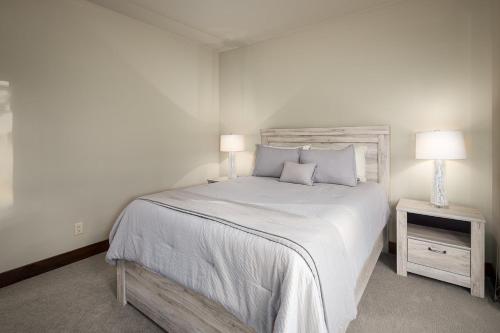a white bedroom with a large bed and two lamps at Tahoe Tranquili-Tree in Kings Beach