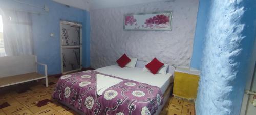 a bedroom with a bed with red pillows at Hong Qi Hotel in Chitwan