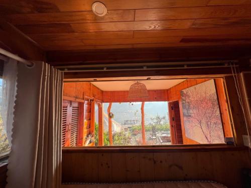 a window in a room with a tree at Lưng Chừng House in Da Lat