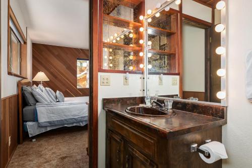baño con lavabo, espejo y cama en The Villa Bossi, en Carnelian Bay