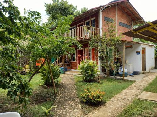 a house with a balcony and a yard at Cabañas Isla Bonita in Cartagena de Indias