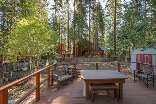 a deck with benches and a picnic table and a cabin at Mirthwood Den in Tahoma