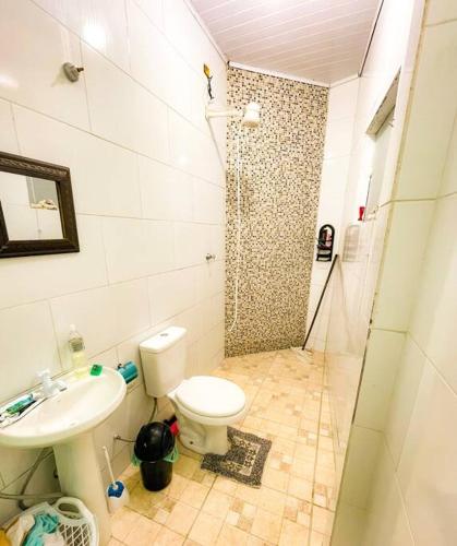 a bathroom with a shower and a toilet and a sink at Kitnet Centro Caraguatatuba in Caraguatatuba