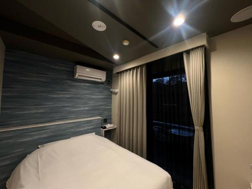 a small bedroom with a bed and a window at Hotel 螢月ｰhozukiｰ Adult Only in Sendai