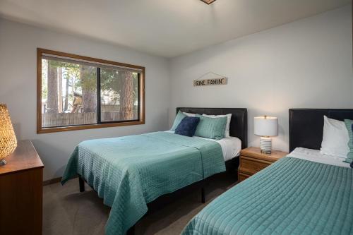 a bedroom with two beds and a window at Sandy Shores Villa in Tahoe Vista