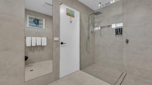 a bathroom with a shower with a glass door at Merimbula Heights in Merimbula