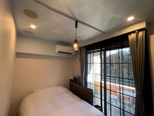 a bedroom with a bed and a large window at Hotel 螢月ｰhozukiｰ Adult Only in Sendai