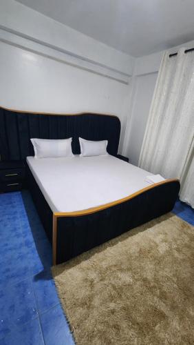 um quarto com uma cama grande e um colchão branco em The flair's Airbnb kisii em Mutomo