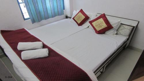 a bed with red and white pillows on it at Ashish Guest House, Goverdhan Vilas in Udaipur